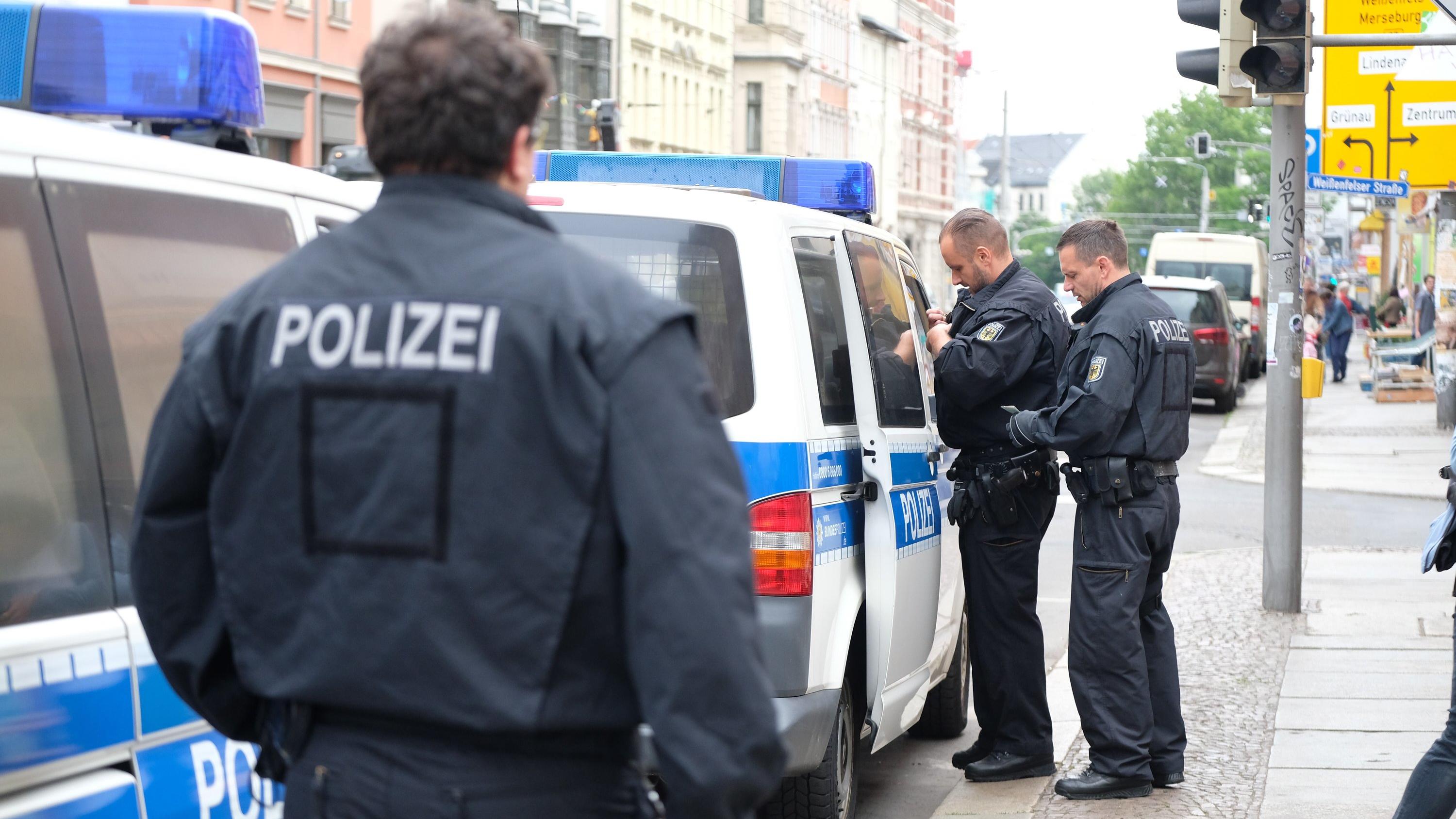 Scheinehen-Razzia in fünf Bundesländern: Hunderte Polizisten im Einsatz gegen Schleuser 13.06.2018, Sachsen, Leipzig: Beamte der Bundespolizei stehen an ihren Fahrzeugen vor einem Mehrfamilienhaus im Leipziger Stadtteil Plagwitz. Dort findet ein Polizeieinsatz im Zusammenhang mit Scheinehen statt. Foto: Sebastian Willnow/dpa-Zentralbild