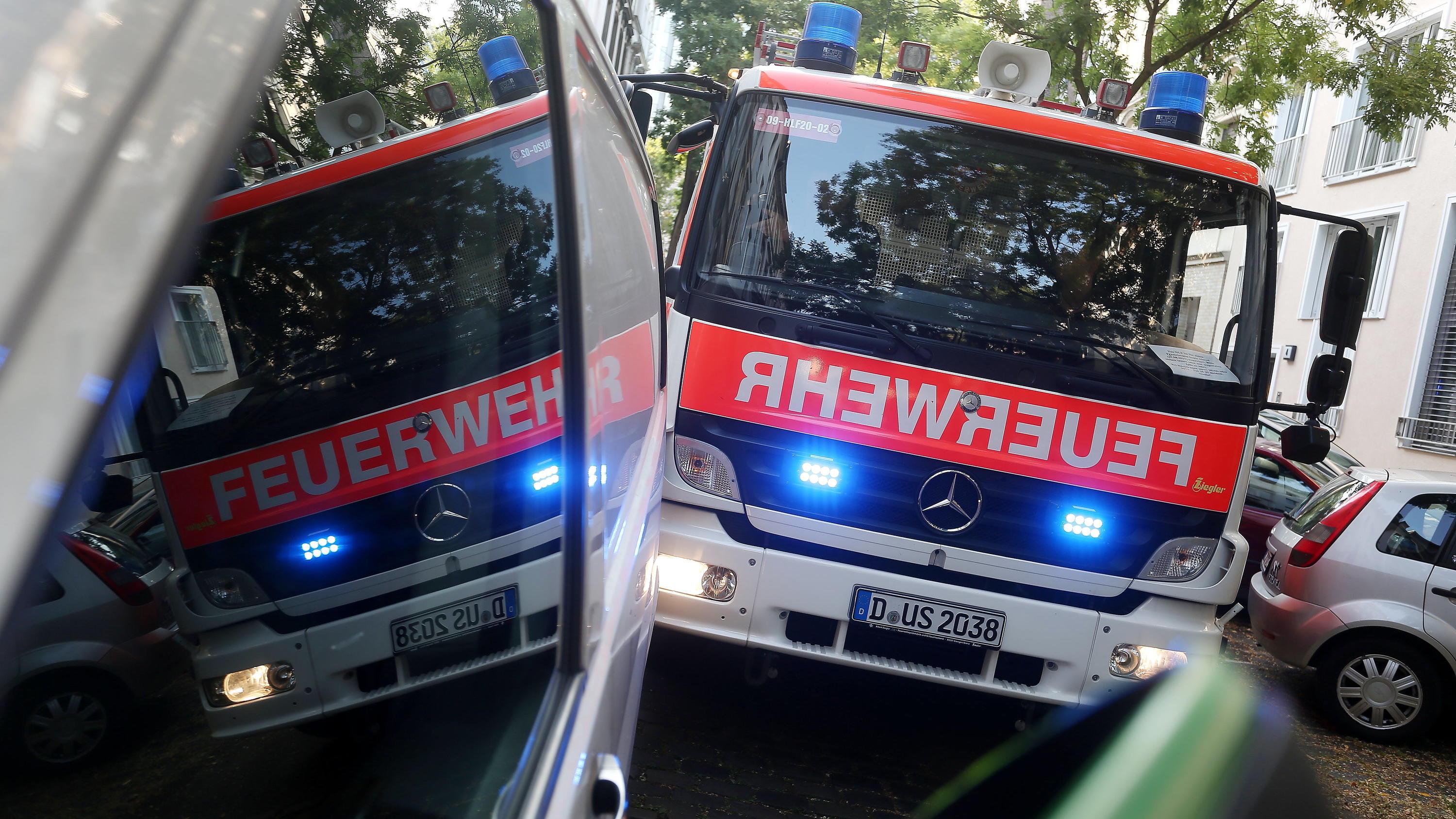 Düsseldorf: Vier Verletzte bei Hausbrand, weil Falschparker den Feuerwehreinsatz behindern Rundfahrt mit der Feuerwehr: Ein durch einen Falschparker blockiertes Feuerwehrauto mit Blaulicht spiegelt sich in den Scheiben des Falschparkers, am 29.08.2017 in Düsseldorf (Nordrhein-Westfalen). Zugeparkte Wohnstraßen und blockierte Rettungswege k