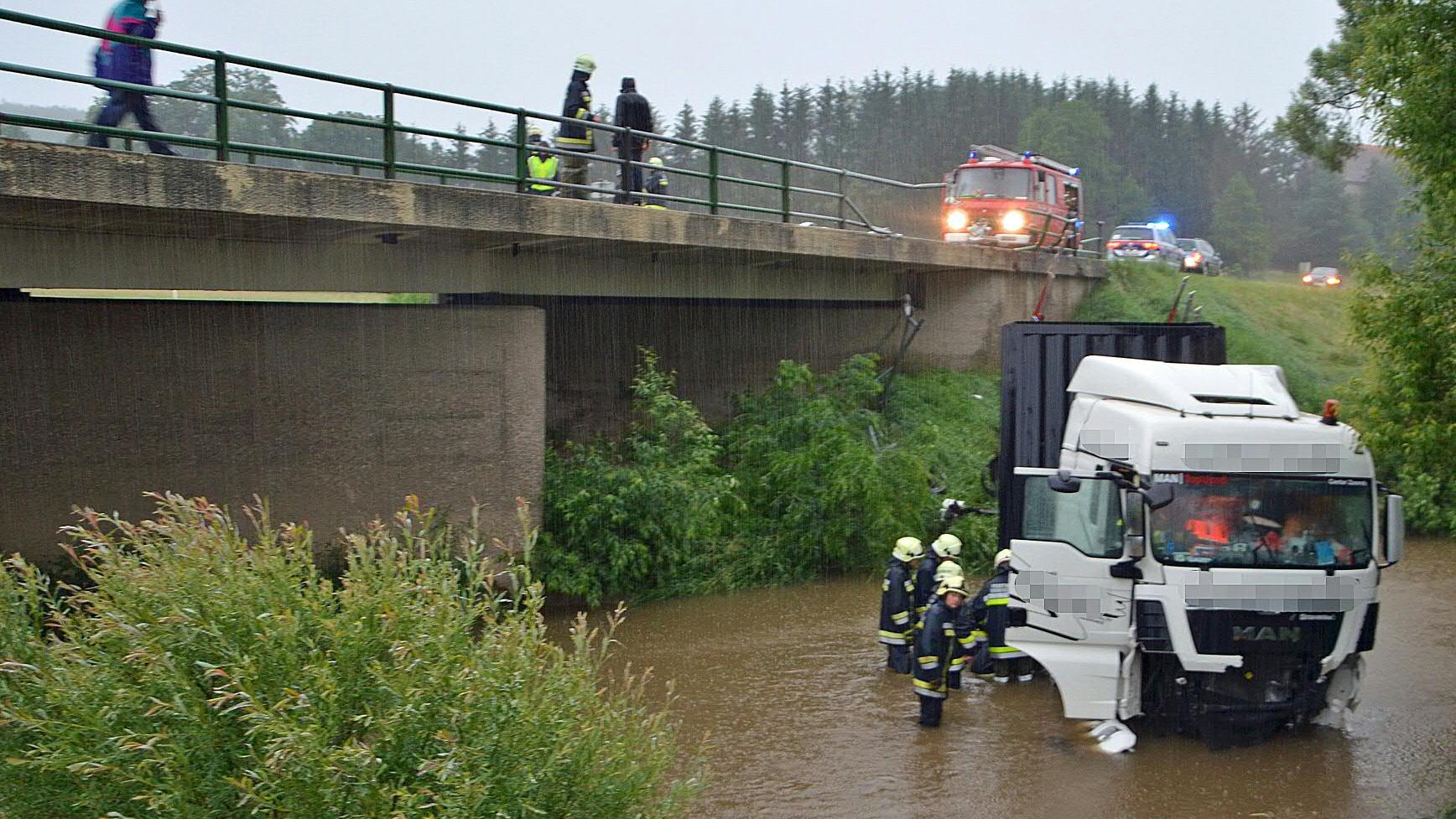 Spektakuläre Bilder: Krasse Unwetter ziehen über den Balkan und Italien 12.06.2018, Österreich, Dobersberg: Das vom Bezirksfeuerswehrkommando Waidhofen an der Thaya zur Verfügung gestellte Foto zeigt einen Lastwagen, der während eines schweren Gewitters von einer Brücke in die Thaya gestürzt ist. Zugfahrzeug un