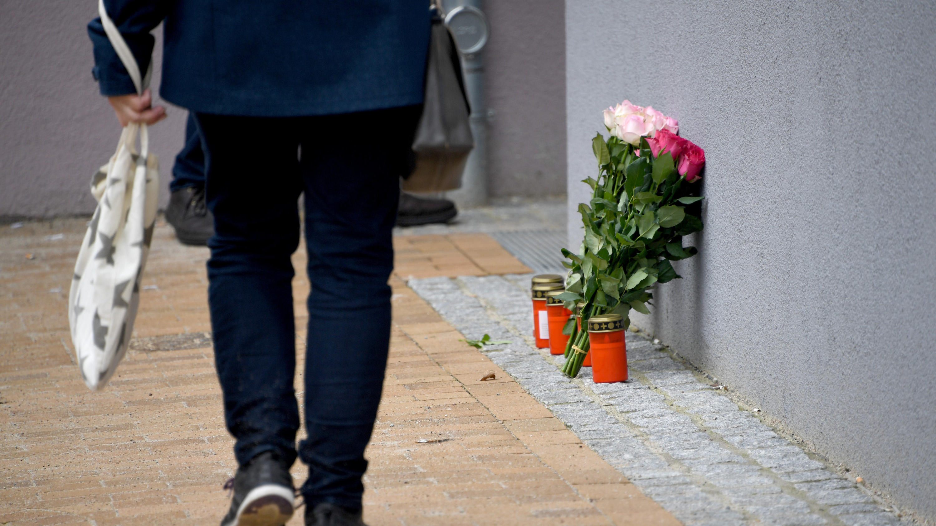17-Jährige in Flensburg erstochen - Tatverdächtiger aus dem Bekanntenkreis 14.03.2018, Schleswig-Holstein, Flensburg: Blumen und Grablichter stehen an einem Mehrfamilienhaus. In dem Gebäude ist am Montag eine 17-Jährige nach Messerstichen gestorben. Bei dem Tatverdächtigen im Fall des gewaltsamen Todes einer 17-Jährigen in
